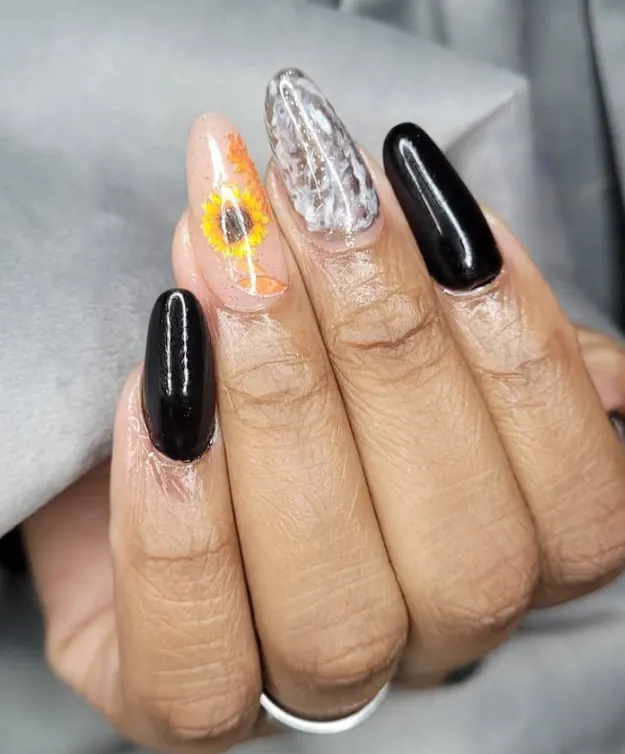 Unhas amêndoa pretas e nude com pintura de girassol e efeito marmorizado